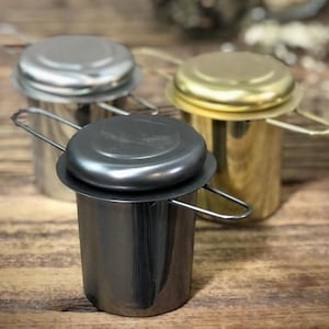 May include: Three tea infusers with lids and handles. The infusers are made of stainless steel and come in silver, gold, and black.