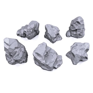 May include: A set of six light gray, unpainted miniature rock formations with jagged, angular surfaces and distinct geometric facets. These small, solid stone-like objects feature varied shapes and sizes, each displaying a rugged, textured exterior.