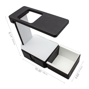 May include: A black and white desk organizer with a drawer. The organizer is 10.26 inches (26 cm) long, 8.11 inches (20.6 cm) high, and 4.63 inches (11.8 cm) wide. The top has a rectangular cutout.