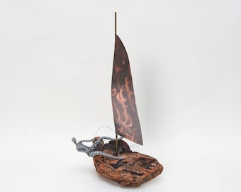 Escultura de velero de madera a la deriva: pieza central de arte náutico costero