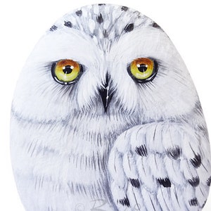 Snowy owl painted on a sea pebble