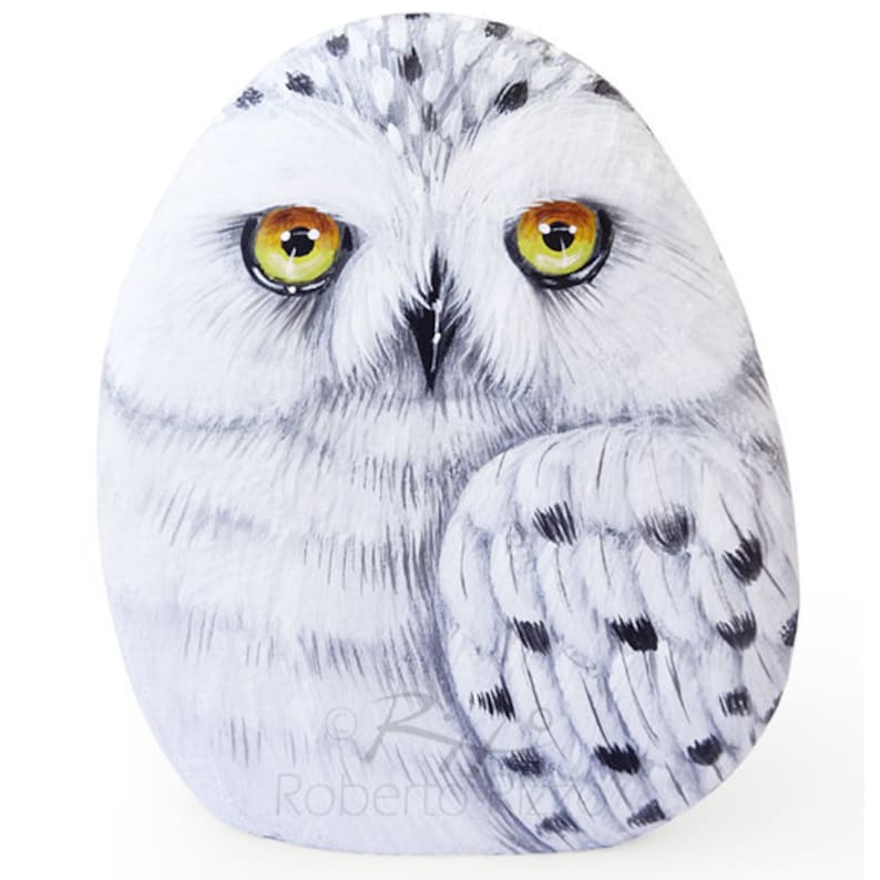 Snowy owl painted on a sea pebble