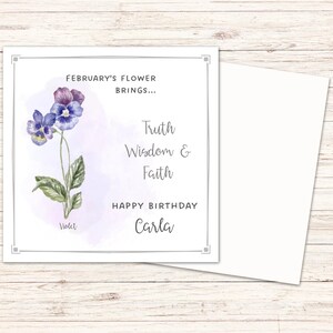 May include: A square greeting card with a watercolor illustration of a violet flower. The card includes text that reads "February's Flower Brings... Truth, Wisdom & Faith. Happy Birthday Carla."