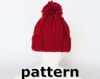 Puede incluir: Gorro de punto rojo con un pompón en la parte superior. El gorro está en una cabeza de maniquí blanca. La palabra "pattern" está escrita debajo del gorro.