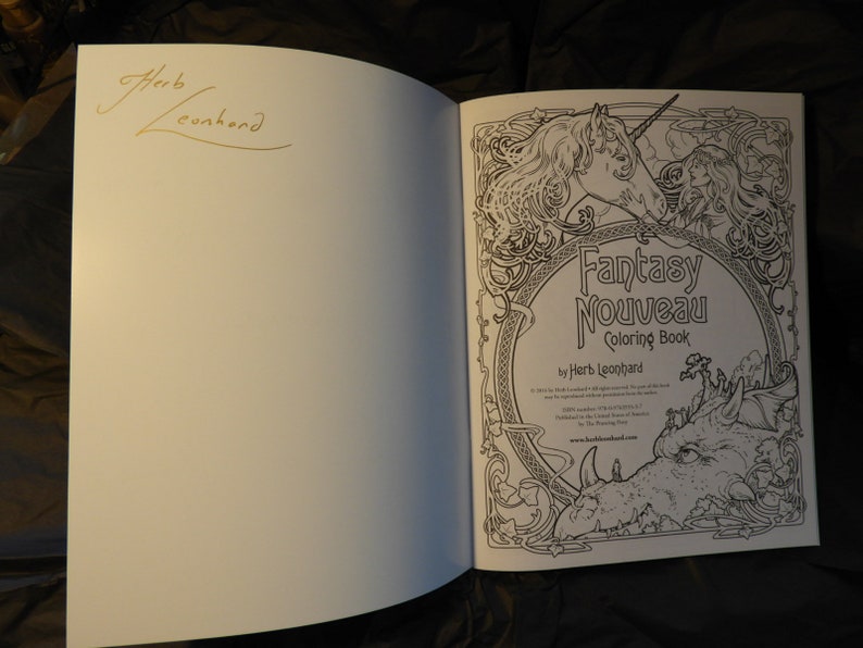 May include: A black and white colouring book with a unicorn and dragon on the cover. The title is "Fantasy Nouveau Coloring Book" by Herb Leonard.