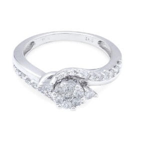 Op de afbeelding: Een zilveren ring met een gedraaide band en een cluster van kleine diamanten in het midden.