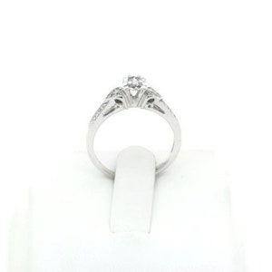 May include: A silver engagement ring with a single round diamond in the center and smaller diamonds set in the band.
