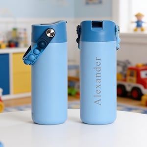 May include: Two light blue water bottles with dark blue lids and carrying handles. One bottle features a dark blue silicone pop-it style strap with circular indentations. The other bottle displays the name Alexander in a grey serif font.