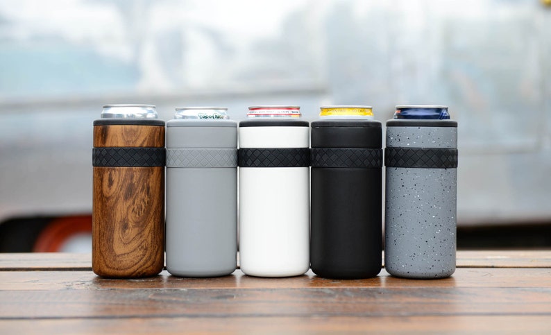 May include: Five insulated can coolers in different colors and patterns. The coolers are made of stainless steel and have a rubber band around the middle. The colors are wood grain, gray, white, black, and speckled gray.