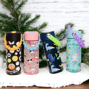 Peut inclure: Quatre bouteilles d'eau r&eacute;utilisables color&eacute;es avec des motifs diff&eacute;rents. Les bouteilles ont un couvercle &agrave; clapet et une poign&eacute;e de transport. Les motifs comprennent des ballons de sport, des chats portant des lunettes, des dinosaures et une sir&egrave;ne.