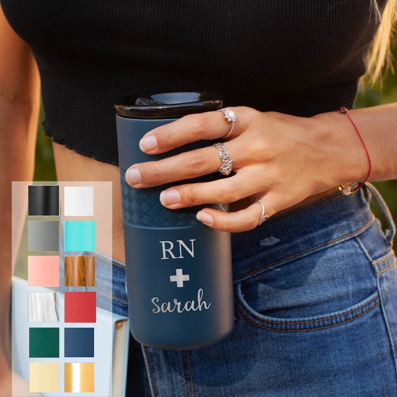 K&ouml;nnte beinhalten: Eine blaue Reise-Thermoskanne mit einem wei&szlig;en und grauen Muster. Die Kanne tr&auml;gt den Text "RN + Sarah" eingraviert.
