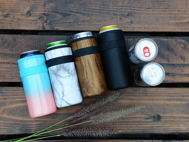May include: Four insulated can coolers in different colors and patterns: blue and pink ombre, white marble, brown wood grain, and black. Two empty aluminum cans are also shown.