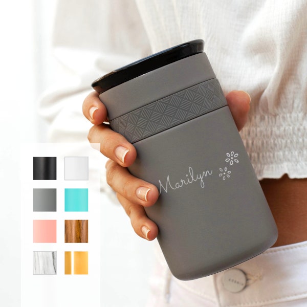 May include: Gray travel mug with a black lid and a white geometric pattern around the middle. The mug has the name "Marilyn" and a small flower design engraved on the side.