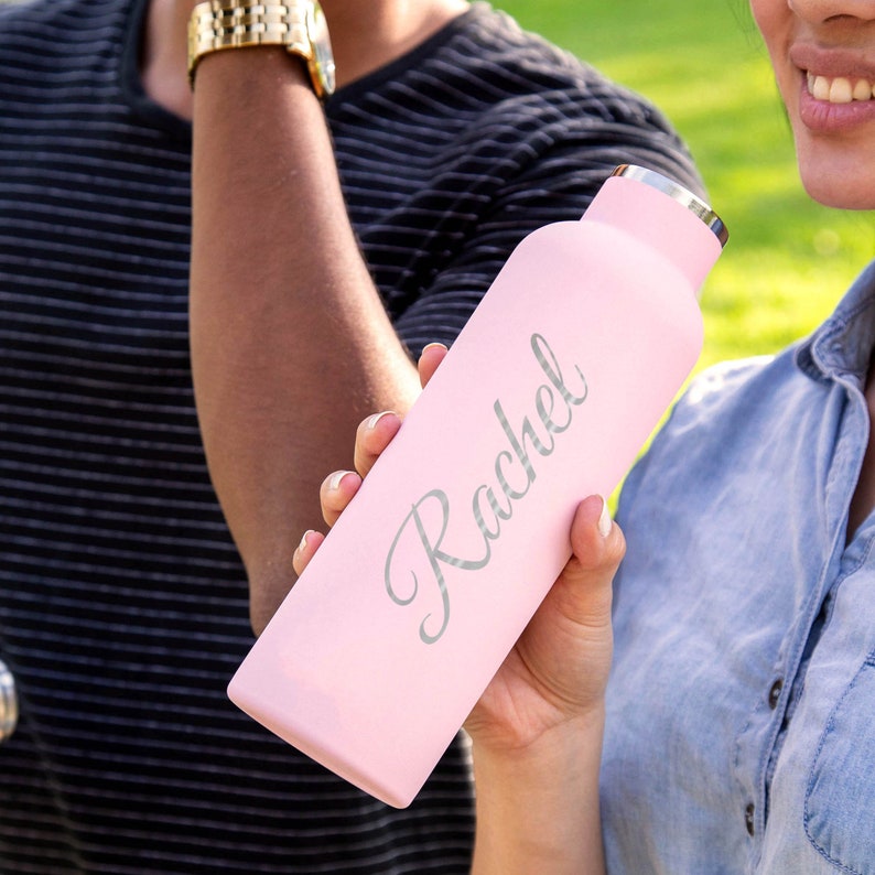 May include: A pink stainless steel water bottle with the name "Rachel" engraved in silver lettering.