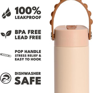 May include: A light peach and cream-colored water bottle with a brown handle. The bottle has the text "100% LEAKPROOF", "BPA FREE LEAD FREE", "POP HANDLE STRESS RELIEF & EASY TO HOOK", and "DISHWASHER SAFE".
