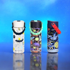 Peut inclure: Trois bouteilles d'eau r&eacute;utilisables avec des motifs color&eacute;s sur le th&egrave;me de l'espace. Les bouteilles ont un couvercle pop-up et une poign&eacute;e de transport. Les bouteilles sont &eacute;tiquet&eacute;es "elemental".