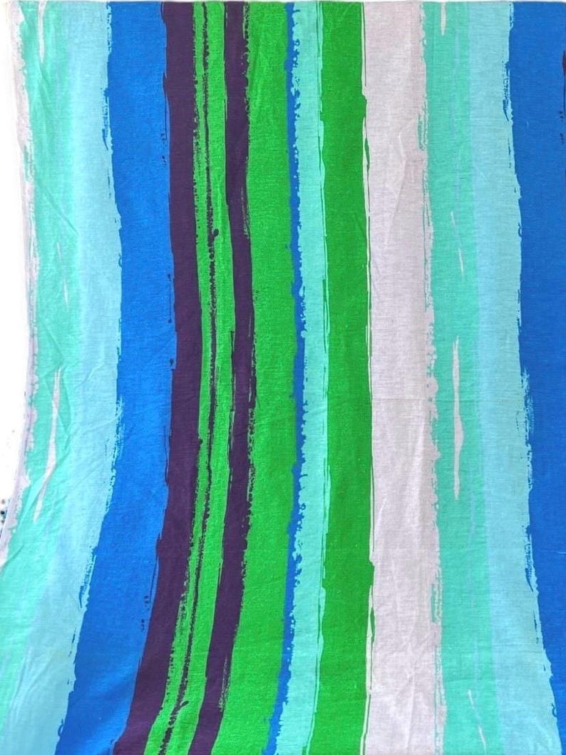 May include: A fabric with a striped pattern in shades of blue, green, and white. The stripes are painted on a white background and have a brushstroke effect.