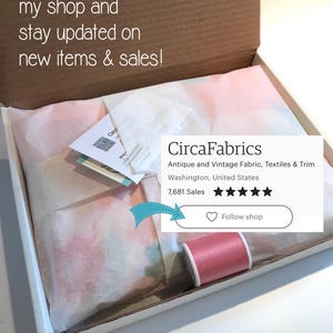 May include: A white box with a pink and blue fabric inside. The box is open and the fabric is visible. The box has a label that says "CircaFabrics" and "Antique and Vintage Fabric, Textiles & Trim". The label also has a five-star rating and the text "7,681 Sales". There is a pink spool of thread next to the label.