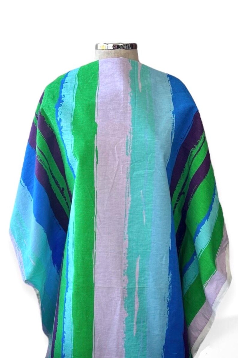 May include: A colorful fabric with a striped pattern in shades of blue, green, purple, and white. The fabric has a brushstroke effect, giving it a unique and artistic look.