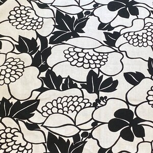 May include: Black and white floral fabric with a large-scale pattern of stylized flowers and leaves.