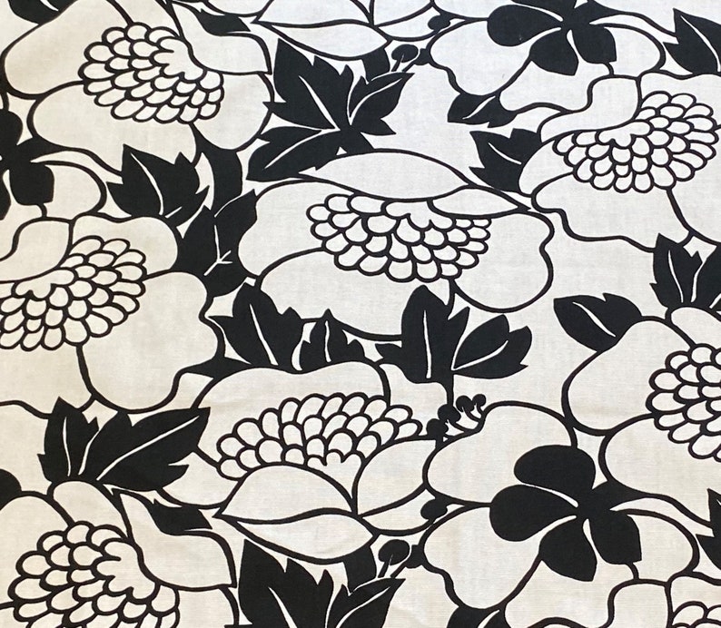 May include: Black and white floral fabric with a large-scale pattern of stylized flowers and leaves.