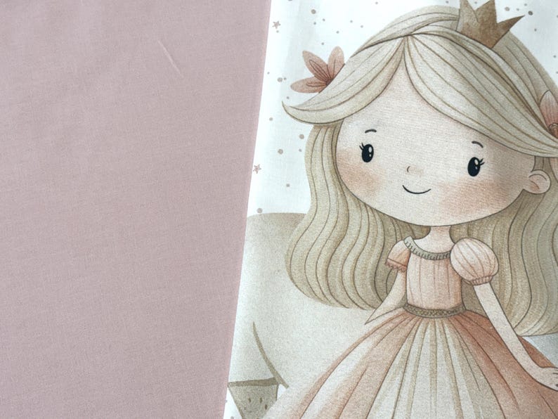 Puede incluir: Un panel de tela con una ilustraci&oacute;n impresa de un personaje con cabello rubio largo, una peque&ntilde;a corona y un vestido color melocot&oacute;n. El personaje est&aacute; rodeado de peque&ntilde;as estrellas. La tela se combina con un textil rosa empolvado.