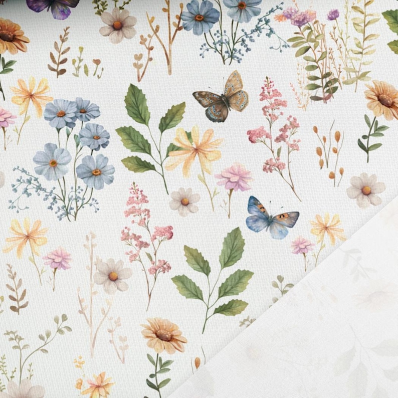 May include: A white fabric with a repeating pattern of blue and yellow flowers, green leaves, and butterflies. The fabric has a subtle texture.