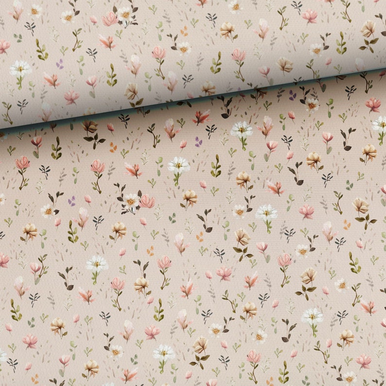May include: A beige fabric with a repeating pattern of small pink and white flowers. The fabric has a subtle texture.
