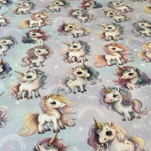 May include: A seamless fabric pattern featuring a repeating design of colorful unicorns with rainbow manes and tails on a light purple background with white stars.