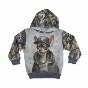May include: A gray hoodie featuring a chihuahua wearing a black cap, denim jacket, and gold chain. The hoodie's design includes various dog breeds in hip-hop attire. The sleeves and hood have a repeating pattern of dogs.