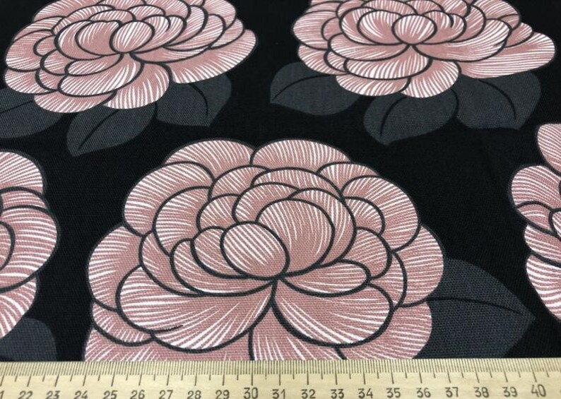 May include: Black fabric with a repeating pattern of large pink and white flowers. The flowers have a detailed, striped design.