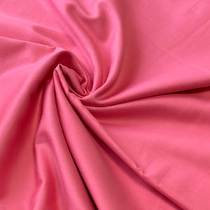 May include: A close-up shot of a vibrant pink fabric with a smooth, silky texture. The fabric is artfully draped and swirled, creating soft folds and shadows. The color is a bright, saturated pink, perfect for apparel or home decor projects.