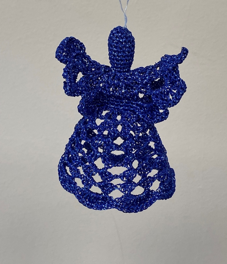 May include: A blue crocheted angel ornament. The angel is made of a delicate, lacy material and has a simple, elegant design.