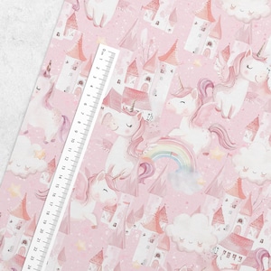 May include: A pink and white seamless pattern featuring unicorns, castles, clouds, and rainbows. The background is a light pink with a subtle sparkle effect.
