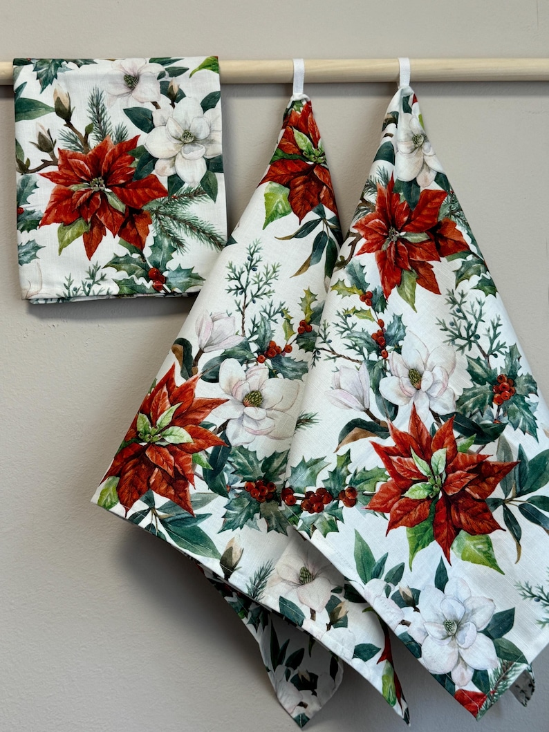 Puede incluir: Tres toallas de cocina blancas con estampado de poinsettia roja, magnolia blanca y bayas de acebo verdes.