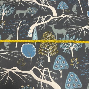 May include: A dark blue fabric with a repeating pattern of white trees, blue and yellow flowers, and deer. The fabric has a subtle texture.