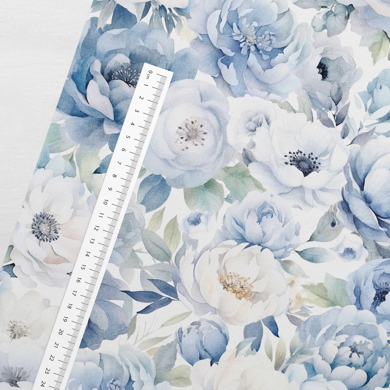 May include: A white fabric with a repeating pattern of blue and white watercolor flowers. The fabric is measured with a ruler in inches.