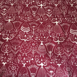 Puede incluir: Una tela roja con un patr&oacute;n blanco repetido de flores estilizadas y mujeres con vestidos. El patr&oacute;n es de estilo arte popular.