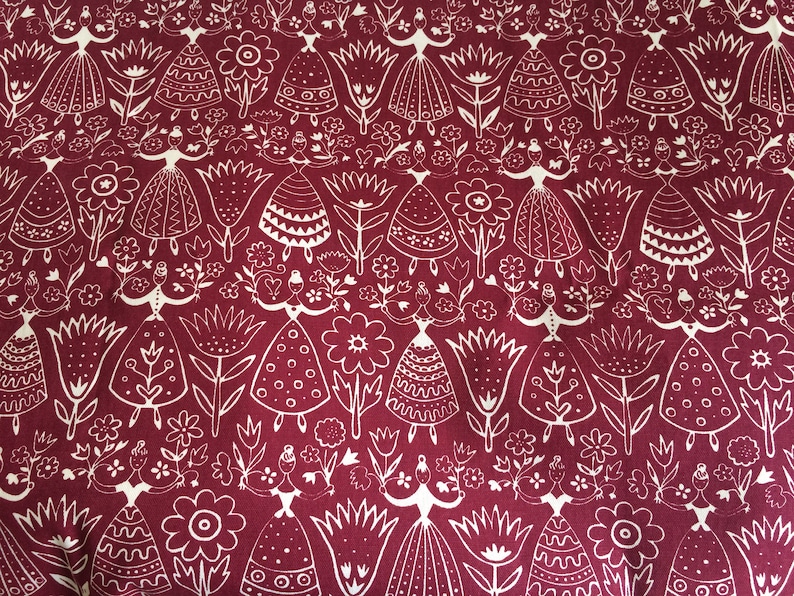 Puede incluir: Una tela roja con un patr&oacute;n blanco repetido de flores estilizadas y mujeres con vestidos. El patr&oacute;n es de estilo arte popular.