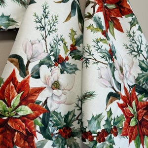 May include: Three white tea towels with a Christmas floral print featuring red poinsettias, white magnolia flowers, green holly leaves, and red berries.