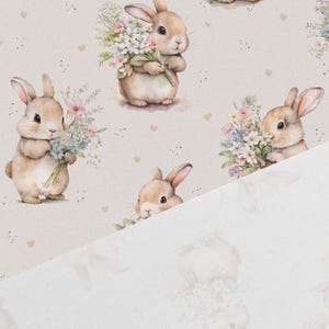 May include: A beige fabric with a repeating pattern of brown bunnies holding bouquets of flowers. The bunnies are surrounded by small hearts and dots.