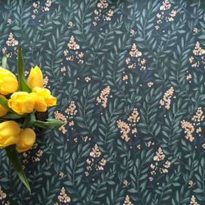 Pode incluir: Um buquê de tulipas amarelas sobre um fundo verde escuro com um padrão floral. O padrão apresenta pequenas flores brancas e folhas verdes.