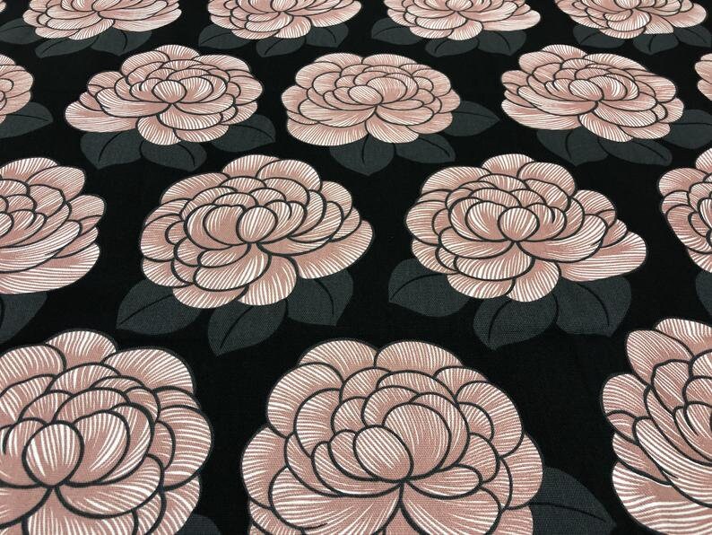 May include: Black fabric with a repeating pattern of large pink stylized flowers. The flowers have a white outline and are drawn with thin lines.