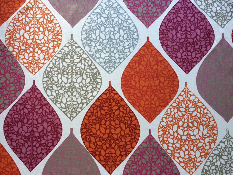 May include: A fabric with a repeating pattern of teardrop-shaped leaves in shades of orange, gray, and pink. The leaves are filled with smaller white leaves.