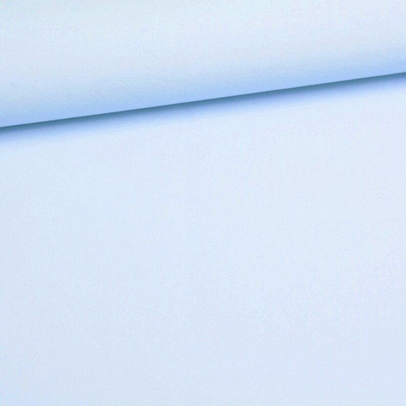 Puede incluir: Una tela de color azul claro s&oacute;lido doblada en el borde superior. El material tiene una textura suave y mate, con un color consistente y uniforme en toda la superficie, mostrando un aspecto limpio y sencillo sin patrones ni detalles.
