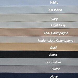 May include: A close-up of 11 different colored ribbon samples. The colors are white, off white, ivory, light ivory, tan-champagne, nude-light champagne, gold, black, light silver, silver, and navy.