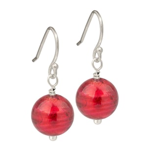 May include: A pair of silver dangle earrings with red glass ball charms. The glass balls have a textured, iridescent finish.