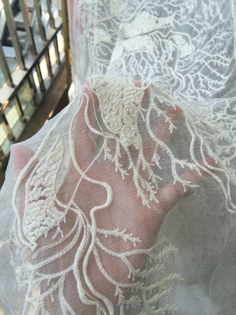 Puede incluir: Tela blanca transparente con un delicado bordado blanco de dise&ntilde;o de rama de &aacute;rbol.