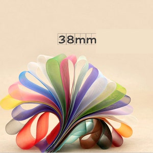 May include: A collection of 12 colorful sheer ribbon rolls, each measuring 38mm wide. The ribbons are arranged in a fan shape, showcasing a variety of colors, including yellow, orange, red, pink, blue, green, and white.