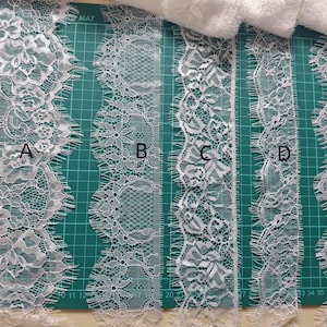 Puede incluir: Cinco diferentes adornos de encaje blanco se muestran sobre una esterilla de corte verde. Los patrones de encaje varían, con diseños florales y geométricos. Los adornos están etiquetados de la A a la E, mostrando diferentes anchos y texturas.